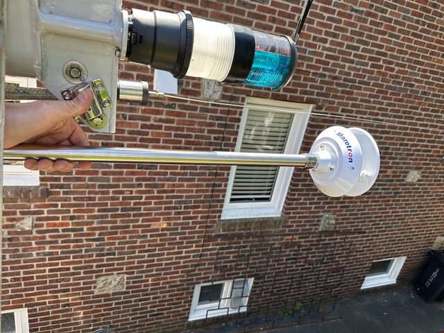 WSO200 on its bent stainless pole being held up to the masthead for positioning