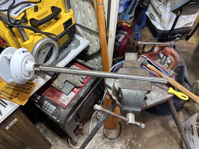 One-inch stainless steel tube clamped in a bench vise being bent to shape for the WSO200 pole mount