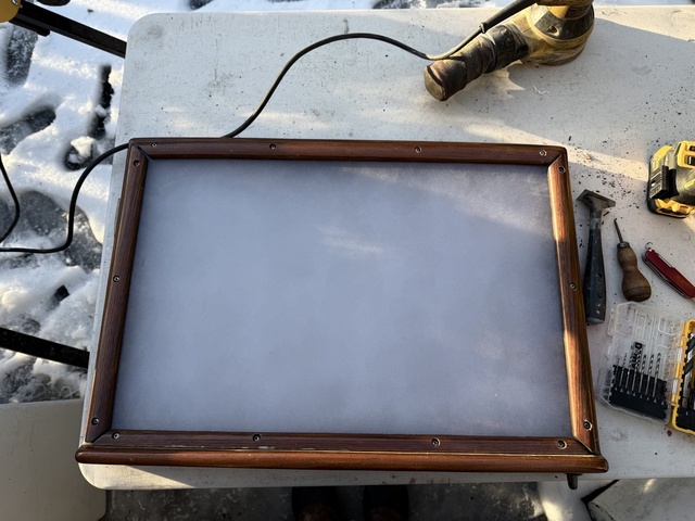New polycarbonate panel dry-fitted in the teak hatch frame with screws positioned, before sealant